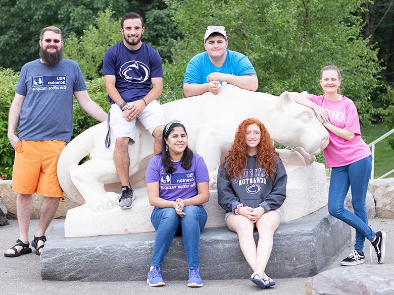六名学生聚集在狮子神社雕像周围