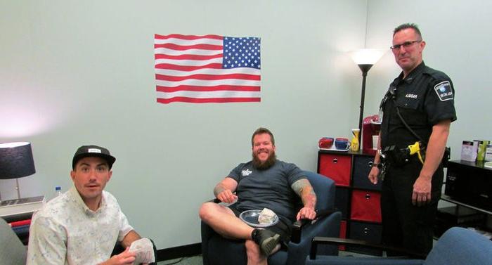 campus police office and two military students sit in comfortable veteran lounge