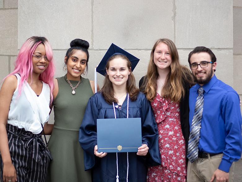 a graduate holding degree posed with four of her friends
