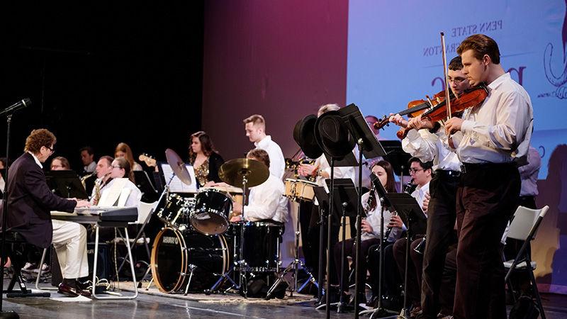 Group of students playing musical instruments on stage